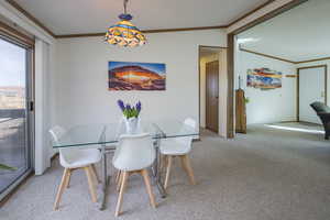 Dining area with crown molding and carpet flooring