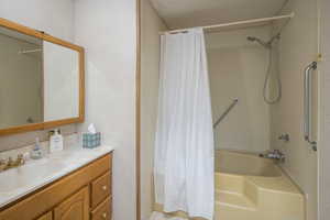 Bathroom with shower / bath combo with shower curtain, vanity, and a textured ceiling