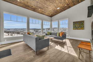 Interior space with high vaulted ceiling, wood ceiling, a mountain view, and light hardwood / wood-style floors