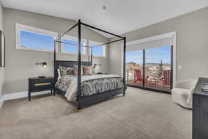 Carpeted bedroom featuring lofted ceiling and access to exterior