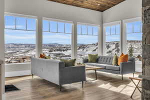 Sunroom with lofted ceiling, a mountain view, and wood ceiling