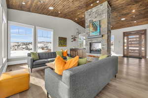 Living room featuring wood ceiling, wood-type flooring, a fireplace, and high vaulted ceiling