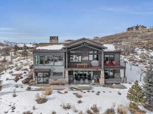 Snow covered rear of property featuring a mountain view