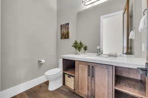 Bathroom with hardwood / wood-style flooring, vanity, and toilet