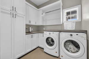 Laundry room featuring cabinets, independent washer and dryer, and sink