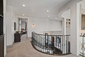 Hallway featuring light colored carpet