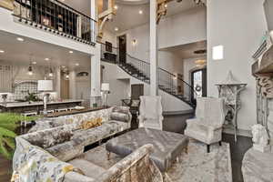 Living room with a high ceiling and dark wood-type flooring