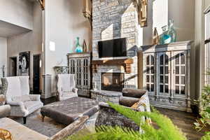 Living room featuring a high ceiling, hardwood / wood-style floors, and a fireplace