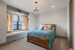 Bedroom featuring light colored carpet and a chandelier