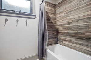 Bathroom featuring shower / bathtub combination with curtain