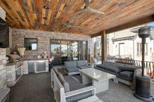 View of patio featuring exterior kitchen, a grill, an outdoor hangout area, and ceiling fan