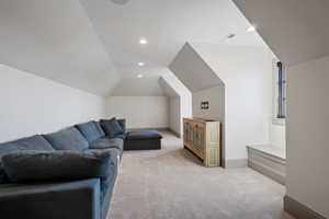 Carpeted living room featuring lofted ceiling