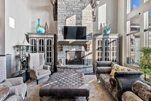 Living room featuring hardwood / wood-style flooring, a fireplace, and a high ceiling