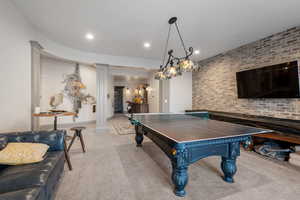 Game room featuring light colored carpet, brick wall, and decorative columns