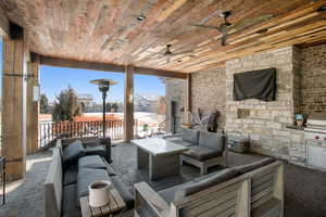 View of patio with ceiling fan, grilling area, and an outdoor living space with a fireplace