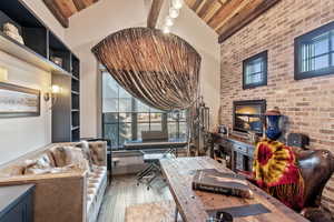 Living room featuring wood ceiling, wood-type flooring, high vaulted ceiling, and beamed ceiling