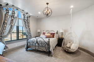 Bedroom with carpet floors and a notable chandelier