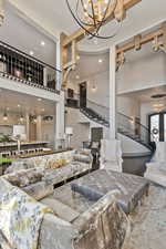 Living room with an inviting chandelier, hardwood / wood-style floors, and a high ceiling