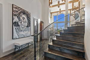 Stairway featuring hardwood / wood-style flooring and beamed ceiling