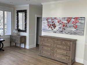 Interior details featuring ornamental molding and hardwood / wood-style floors