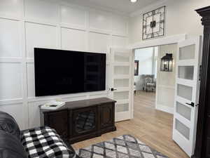 Living room featuring crown molding and light hardwood / wood-style flooring