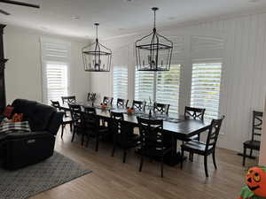 Dining space with crown molding, hardwood / wood-style floors, and a notable chandelier