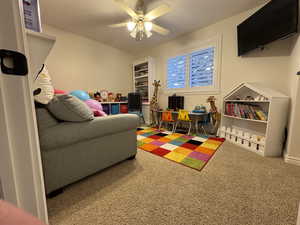 Playroom with ceiling fan and carpet