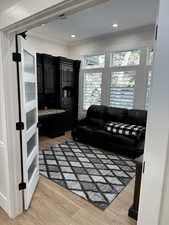 Living room featuring crown molding and light hardwood / wood-style flooring