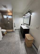 Bathroom featuring vanity, toilet, an enclosed shower, and a textured ceiling