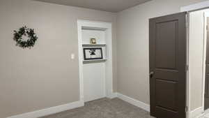 Hallway featuring light colored carpet