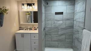 Bathroom featuring vanity and tiled shower