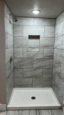 Bathroom with tiled shower and a textured ceiling