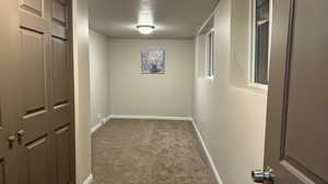 Hall featuring carpet floors and a textured ceiling