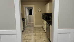 Kitchen with sink, dark stone countertops, backsplash, stainless steel appliances, and white cabinets