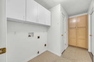 Washroom with hookup for a washing machine, cabinets, a textured ceiling, hookup for a gas dryer, and hookup for an electric dryer