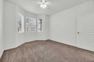 Empty room featuring carpet floors and ceiling fan