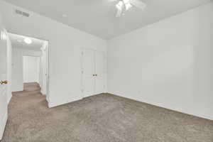 Unfurnished bedroom featuring ceiling fan, carpet flooring, and a closet