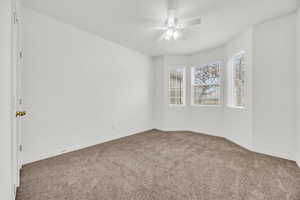 Spare room with ceiling fan and carpet