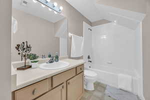 Full bathroom with vanity, tiled shower / bath, and toilet