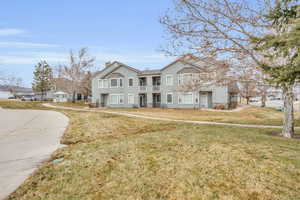 View of front of house with a front lawn and a balcony