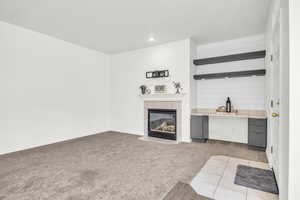 Carpeted living room featuring a tiled fireplace