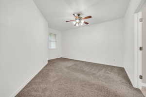 Carpeted empty room featuring ceiling fan