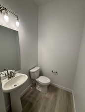 Bathroom with hardwood / wood-style floors, sink, and toilet