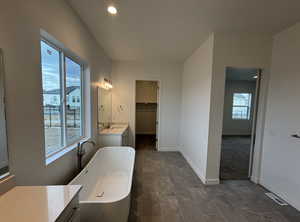 Bathroom featuring vanity and a tub to relax in