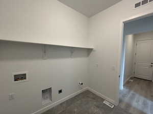 Clothes washing area with hookup for a washing machine, dark wood-type flooring, hookup for an electric dryer, and hookup for a gas dryer