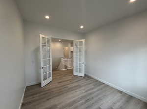 Empty room with wood-type flooring and french doors