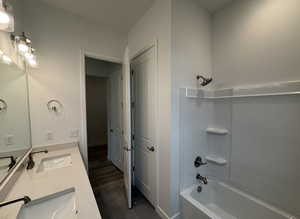 Bathroom with shower / tub combination, vanity, and tile patterned flooring