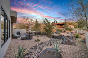 Yard at dusk with outdoor lounge area and a patio