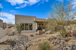 Back of house with stucco siding and a patio