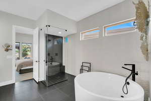 Bathroom featuring tile patterned flooring and separate shower and tub